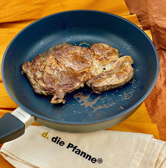 Alugusspfanne Edition 13 Tiefe Pfanne mit Antihaftbeschichtung B-Ware: tiefe Aluguss-Pfanne Edition 13 mit gebratenem Fleisch und antihaftbeschichteter Oberfläche