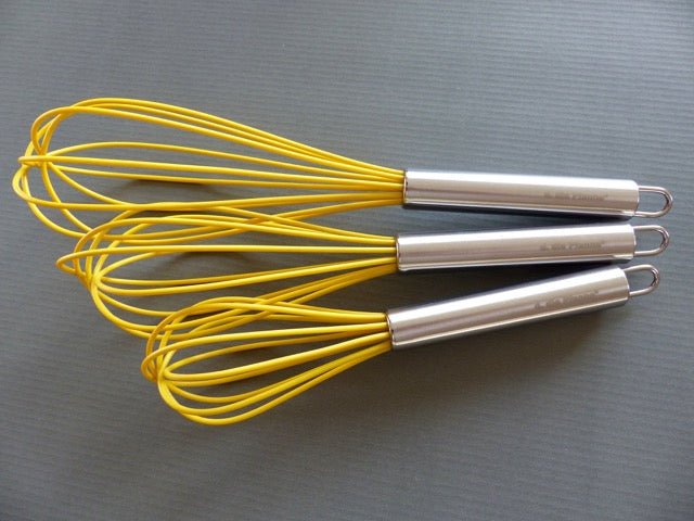 Schneebesen-Set mit curryfarbenem Silikonkopf und Edelstahlgriff, in drei Größen.