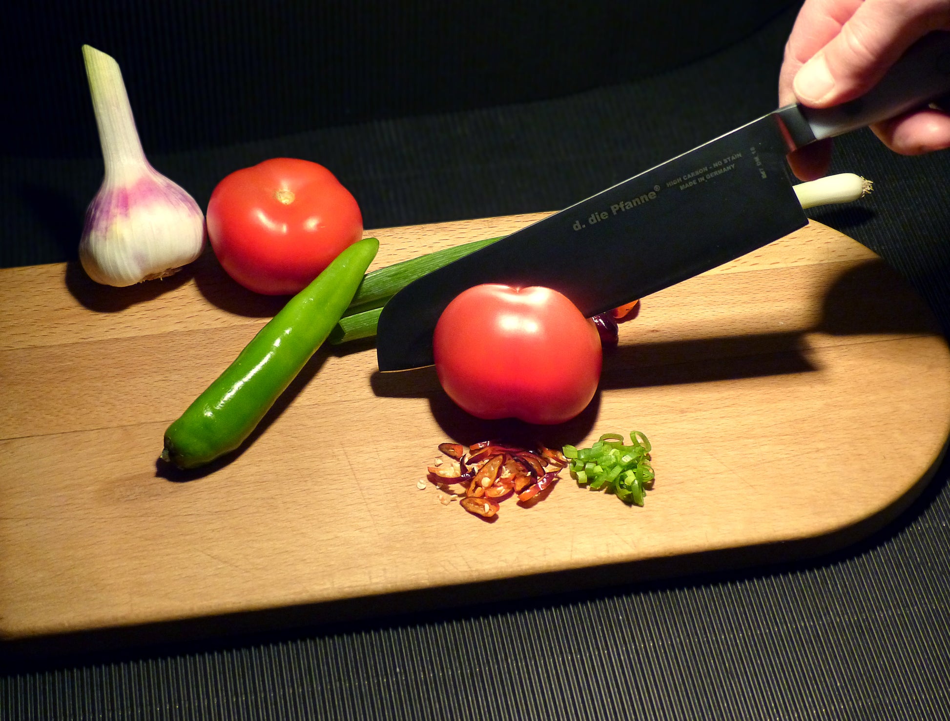 Küchenmesser Edition 7 von die Pfanne® schneidet Tomaten.