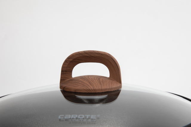 Detailaufnahme des Glasdeckels der Serie 90s Wood: Man sieht den Soft-Touch-Henkelknauf mit kastanienfarbenem Holzmaserungs-Druck und das Logo des Hestellers CAROTE in Hellgrau.
