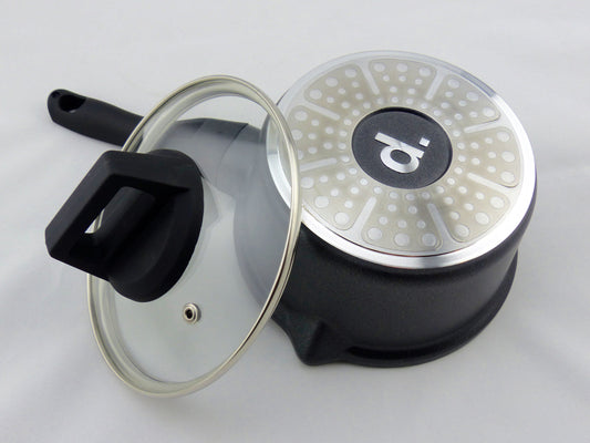 Saucenpfännchen aus Aluguss: schwarzer Stieltopf Edition 9 im Durchmesser 16 cm in freigestellter Aufnahme von unten. Man sieht den Induktionsboden mit dem Logo 'd.'. Angelehnt ist der dazugehörige Glasdeckel mit Metallrand und Dampfaustrittdüse.