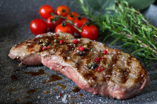 Nahansicht von Fleisch in der Grillpfanne Edition 3 von die Pfanne: Man sieht die Grillrillen in der Bratfläche und schöne Grillmarken auf dem Steak sowie die grau/schwar/weiß gesprenkelte Antihaftbeschichtung deutlich.